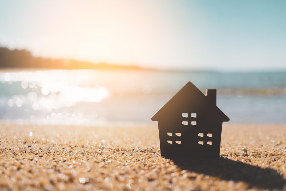 Ein Hausmodell aus Holz am Strand