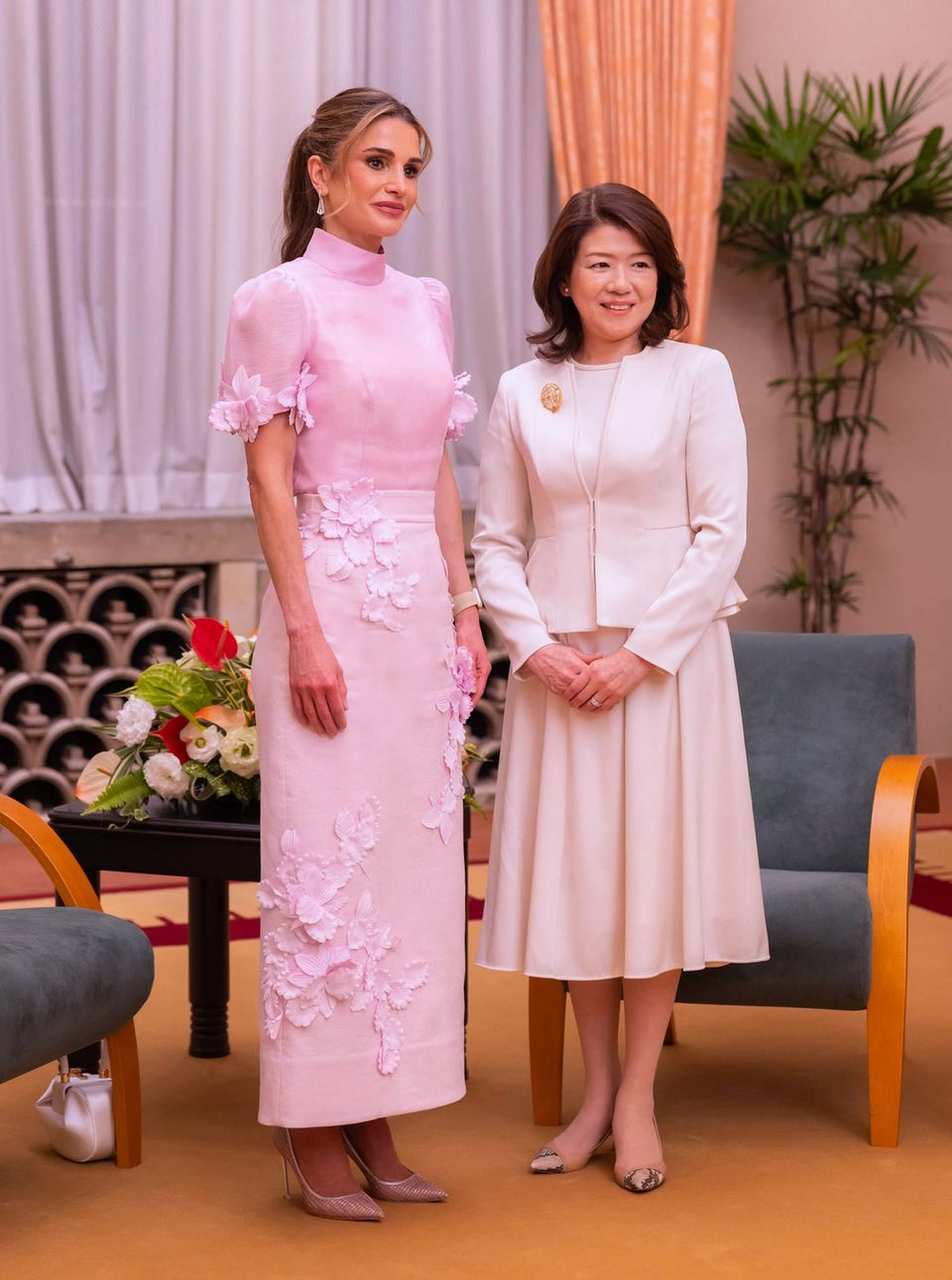 Mit diesem Blüten-Ensemble von Zimmermann in Rosa macht sich Königin Rania bei ihrem Staatsbesuch in Japan nicht nur bei Yuko Kishida, der Frau des japanischen Premierministers Fumio Kishida beliebt. In Japan blühen nämlich zur Zeit die Kirschbäume, und die Kirschblüte gehört zu den wichtigsten Symbolen des Landes, sie steht für Schönheit, Aufbruch und Vergänglichkeit. Passender könnte ein Outfit kaum ausgesucht sein.