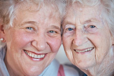 Zwei ältere Frauen mit grauen Haaren lachen in die Kamera