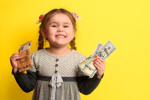 Kleines Mädchen hält Geldscheine in der Hand