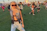 Zum Auftakt des Coachella-Festivals trägt Influencerin Xenia Adonts einen coolen Look aus Jeans und Glitzerweste. Unter der Nietenweste trägt sie Spitzenunterwäsche. Eine eckige Sonnenbrille und derbe Stiefel runden den coolen Look ab.