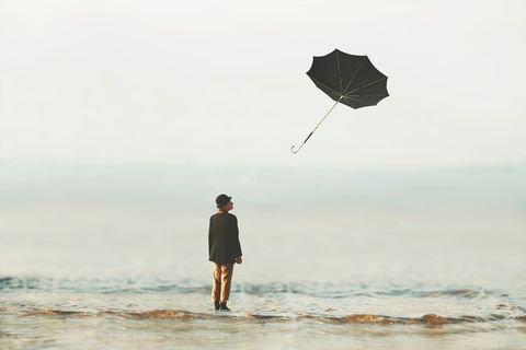 Psychologie: Eine Frau mit einem wegfliegenden Schirm