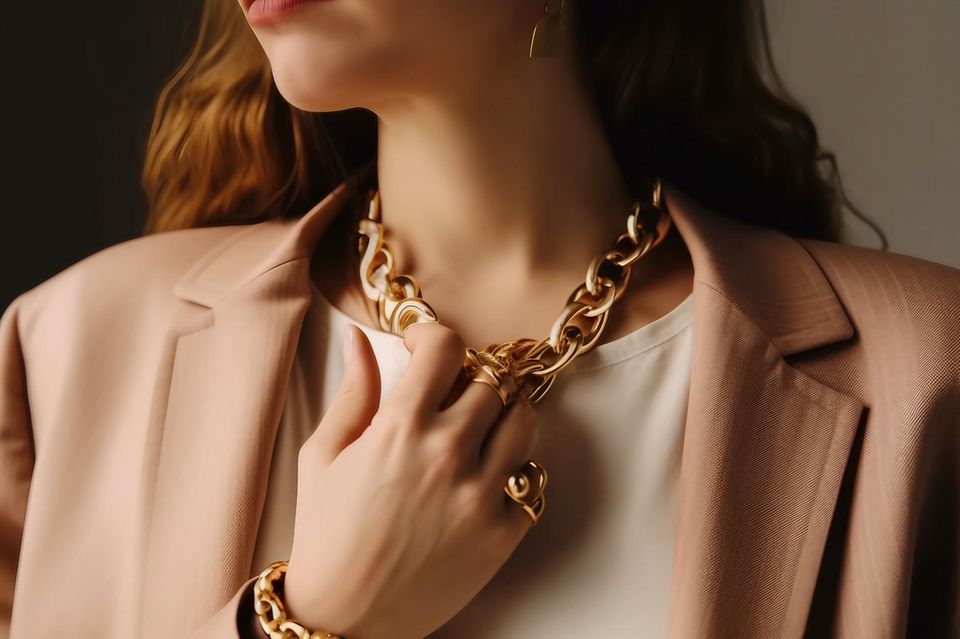Gliederketten Trend: Frau trägt eine goldene, derbe Kette zum Blazer