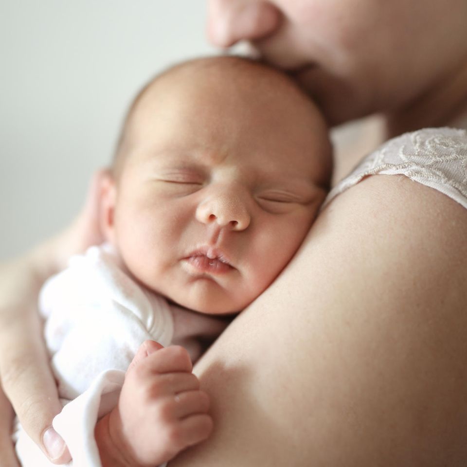 Ein Baby ist auf dem Arm seiner Mutter.