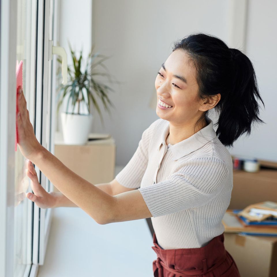 Frau putzt Fenster | "Simply Clean"-Methode: Mit täglich nur 10 Minuten Arbeit die Wohnung sauber halten