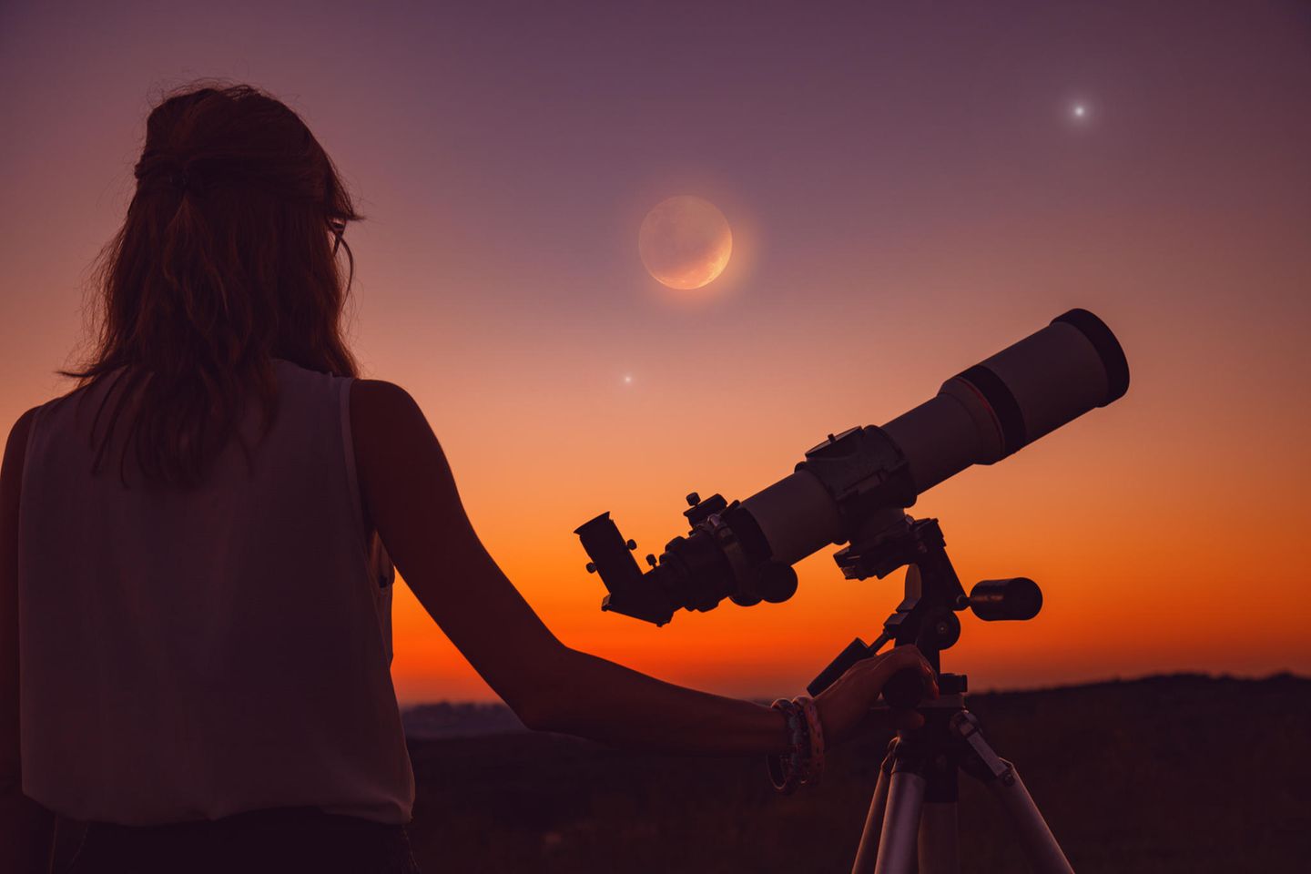 Horoskop: Eine Frau schaut eine Mondfinsternis an