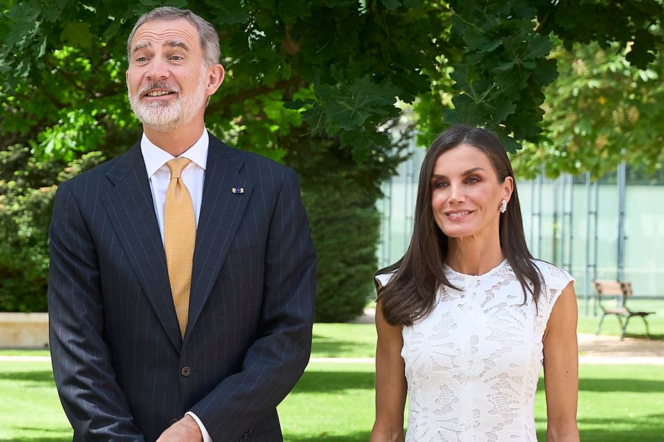 Mit ihrem weißen Midikleid aus Spitze der Marke Sfera läutet Königin Letizia den Frühling ein. Dazu trägt sie nudefarbene Pumps. In dem scheinbar schlichten Outfit fällt jedoch ein frühlingshaftes Detail ins Auge.