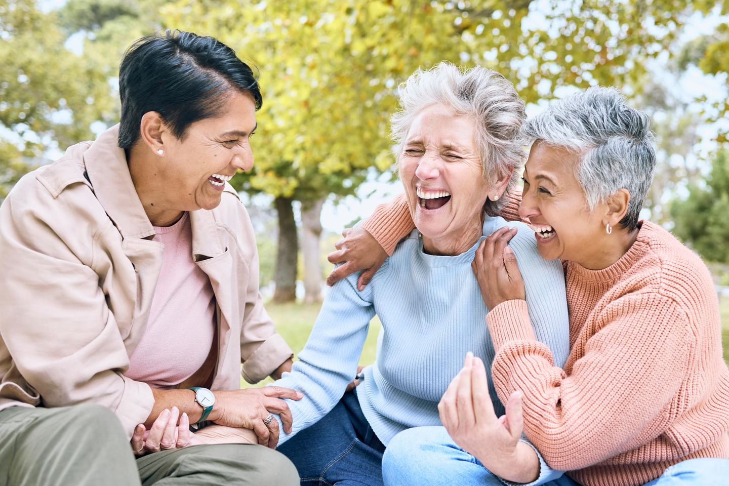 Drei lachende Frauen auf einer Wiese