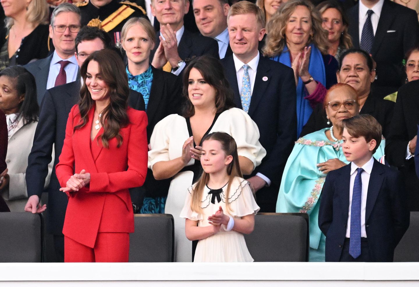 Für diese modische Meisterleistung darf sich Kate auch selbst ein wenig beklatschen. Beim Krönungskonzert auf dem Geländer von Windsor Castle präsentiert die 41-Jährige einen asymetrischen Hosenanzug von Alexander McQueen in leuchtendem Rot. Das Recycler-Stück, das sie zuvor schon einmal trug, entspricht damit nicht nur der Philiosophie von King Charles eine sparsamere Monarchie zu prägen, sondern bildet im Zusammenspiel mit dem weißen Kleid von Tochter Charlotte und dem blauen Anzug von Sohn George auch die Farben des nationalen Union-Jack.