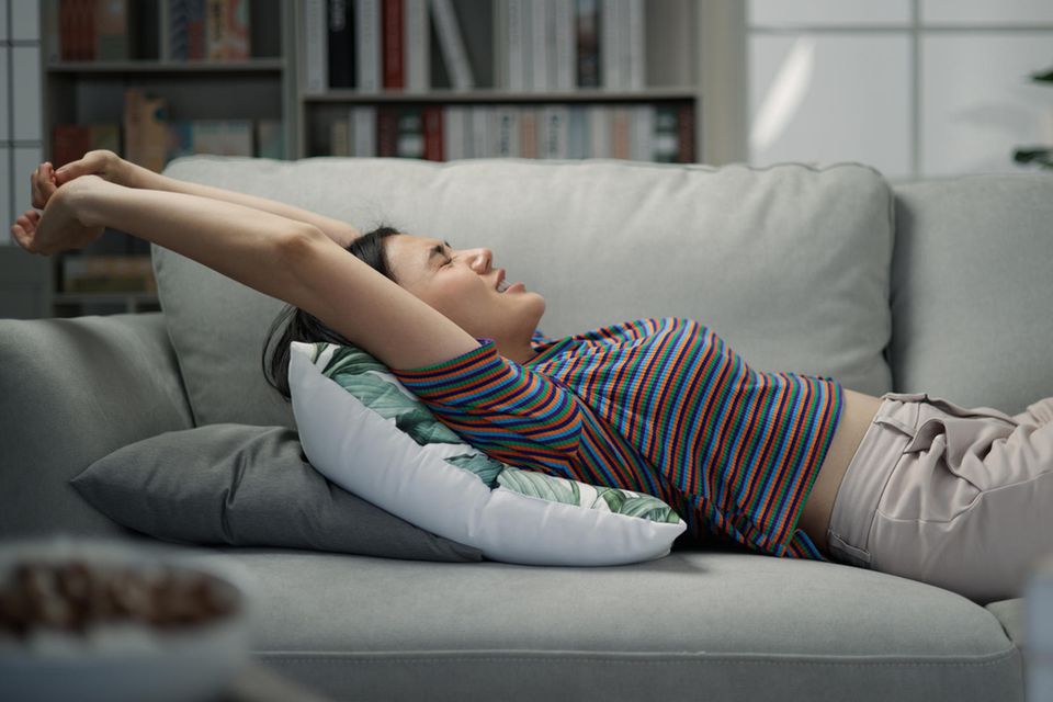 Schlafgewohnheiten: Frau schläft auf Sofa
