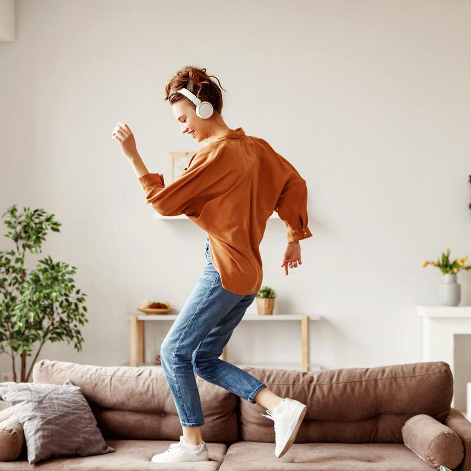Hauhalt: Eine Frau tanzt auf der Couch