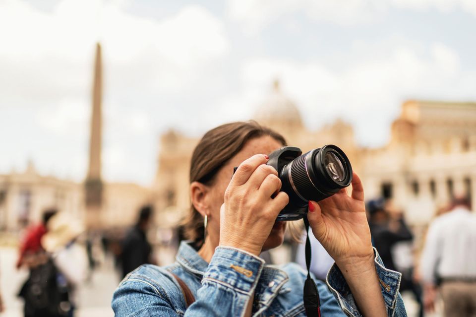 Eine Frau fotografiert die Architektur einer Innenstadt