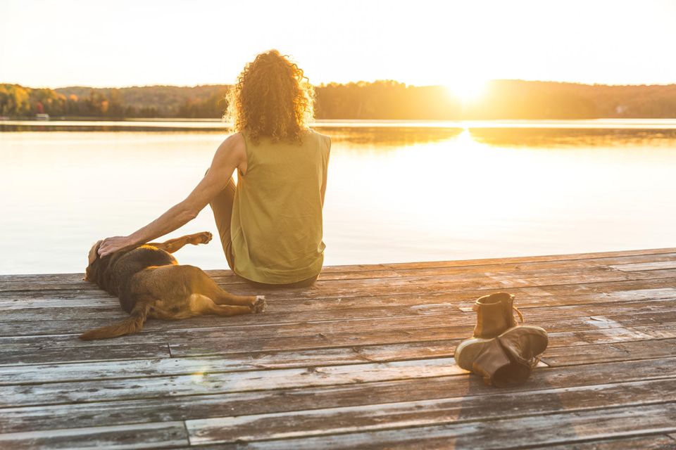 Psychologie: Eine Frau mit Hund an einem See