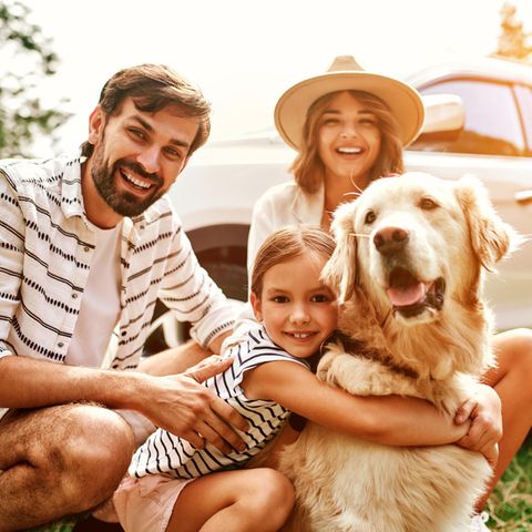 Eine Familie die mit ihrem Hund in den Urlaub fährt