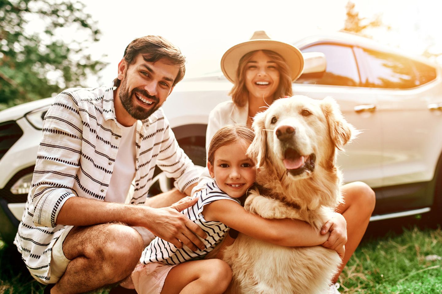 Eine Familie die mit ihrem Hund in den Urlaub fährt