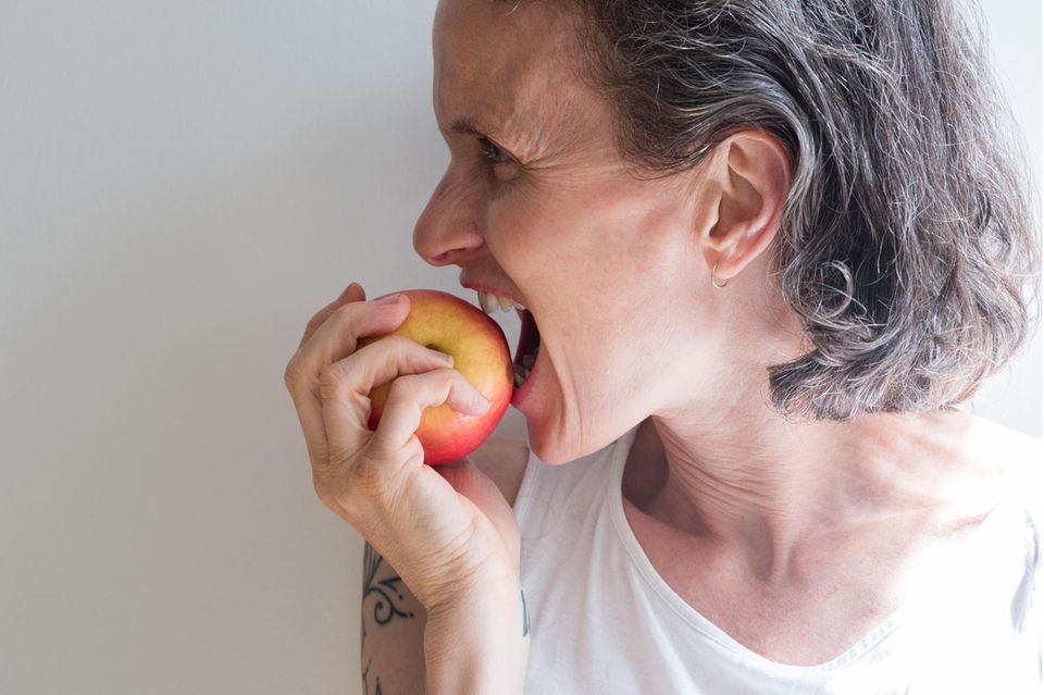 Eine Frau isst einen Apfel