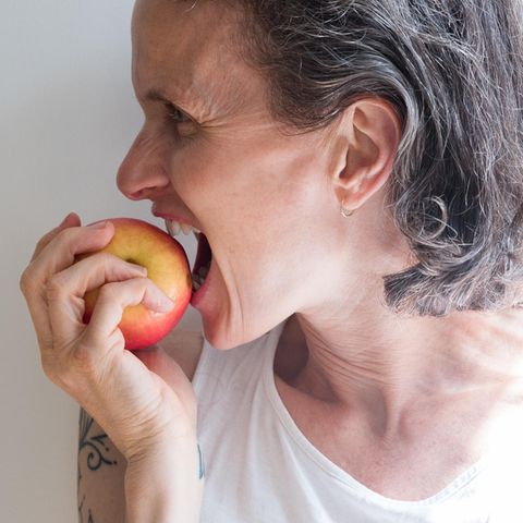 Eine Frau isst einen Apfel