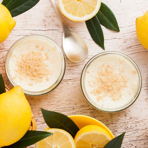 Zitronencreme im Glas neben Zitronen