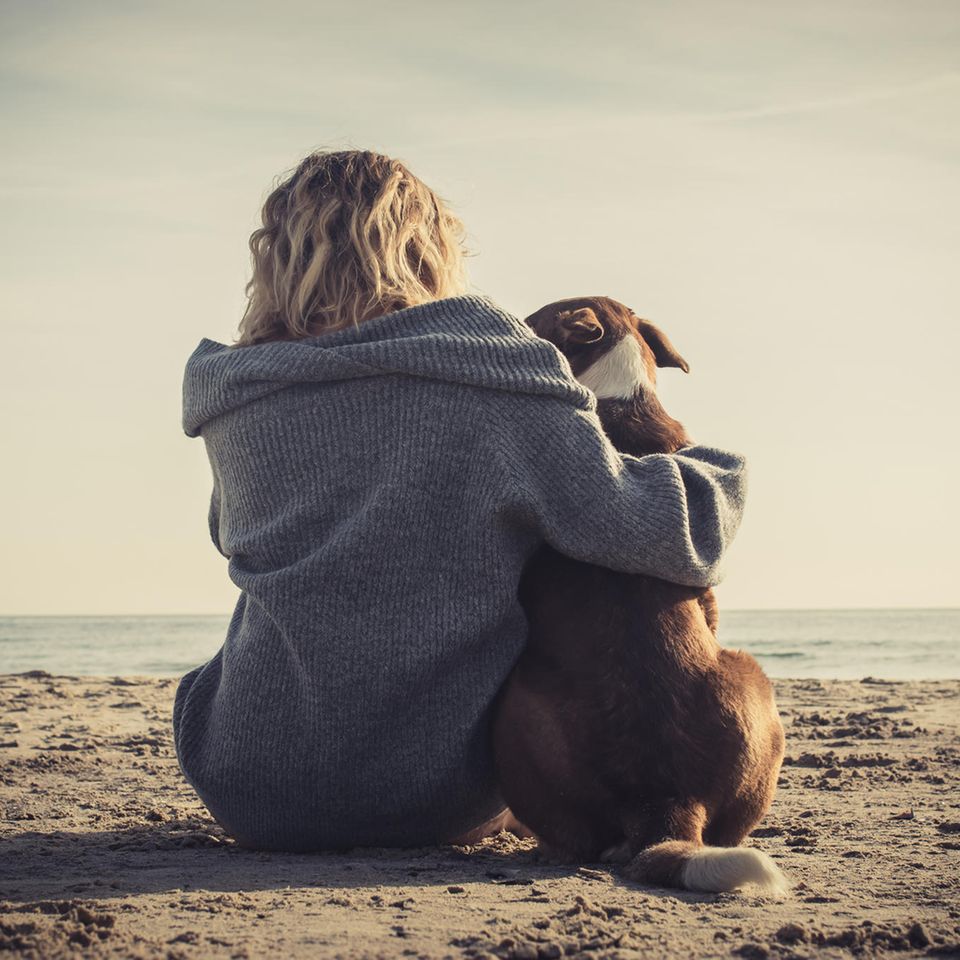 Psychologie: Eine Frau mit Hund am Meer