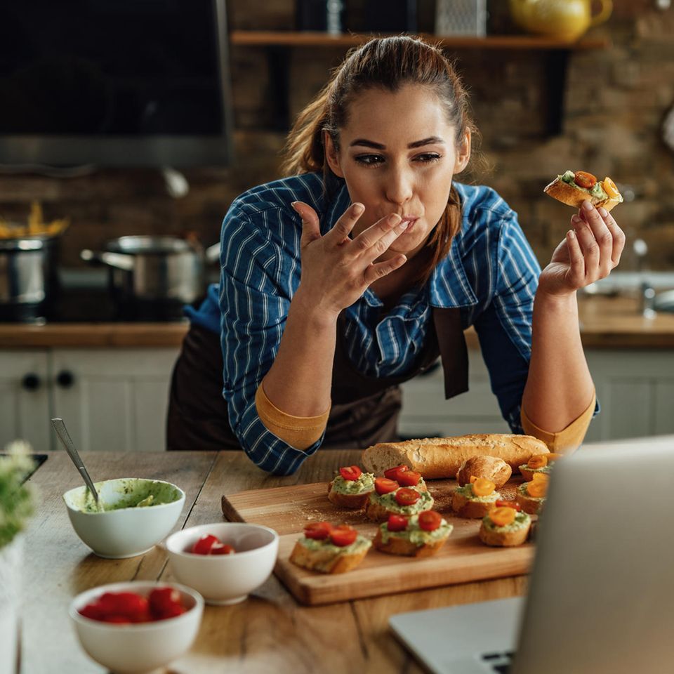 Abnehmen mit links: Frau isst Bruscetta in der Küche