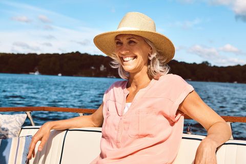 Frau sitzt auf einem Boot und lacht