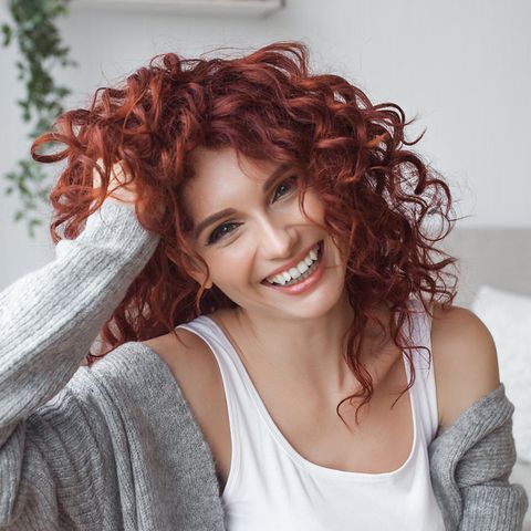 Vitamine für Haare: Eine rothaarige Frau lächelt in die Kamera