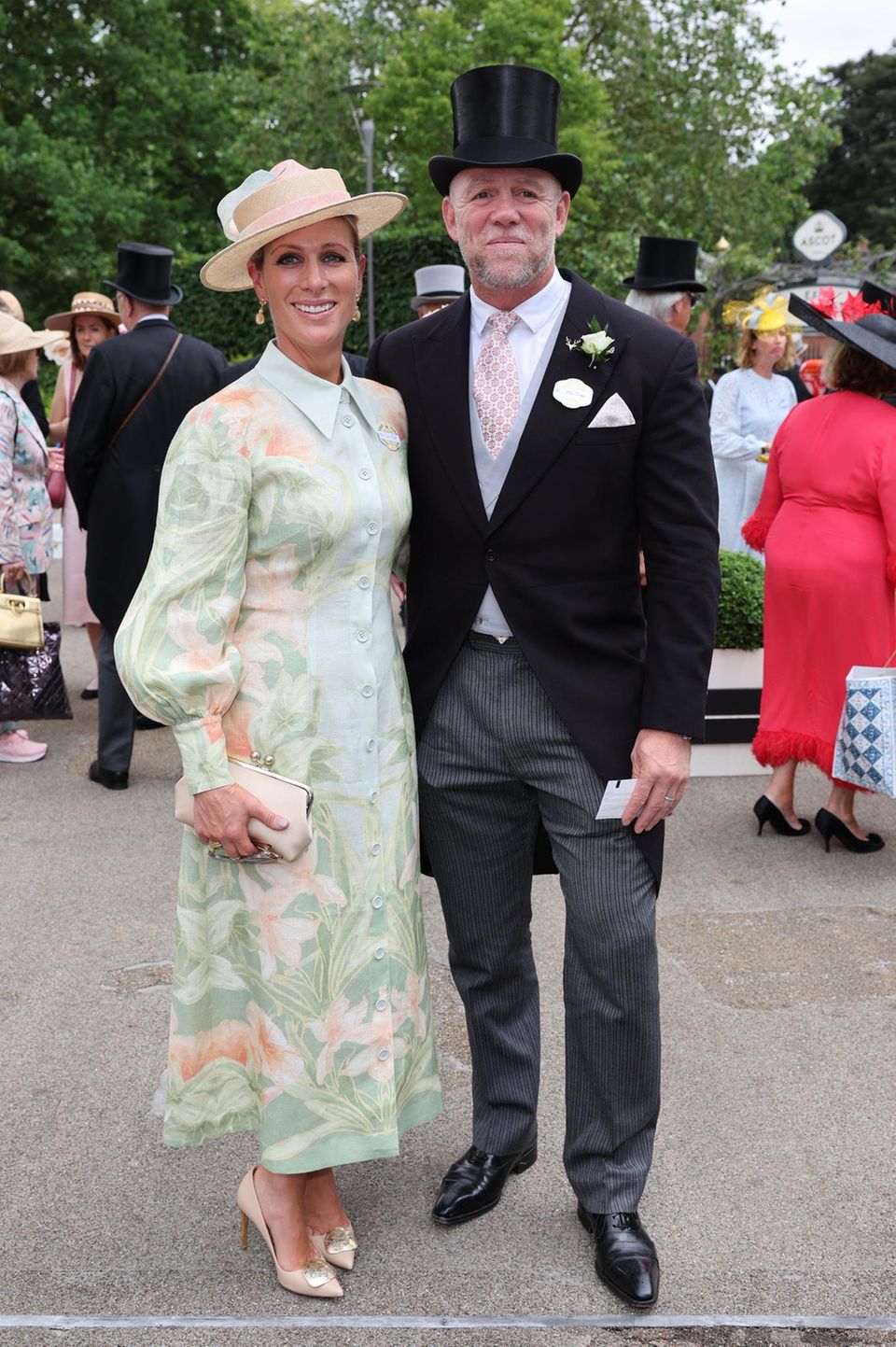 Als modische Einheit erscheinen Zara und Mike Tindall beim Royal Ascot 2023. Zara strahlt in einem eleganten Kleid mit floralem Muster von Leo Lin, das vor allem durch seine pastelligen Farben begeistert. Sommerliche Töne, auf die auch Mike Tindall mit seiner Krawatte setzt.