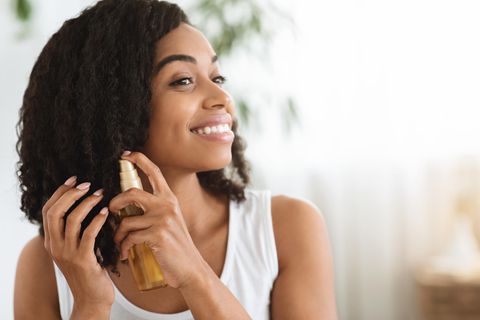 Haaröl ohne Silikone: Eine Frau benutzt ein Öl für ihre Haare