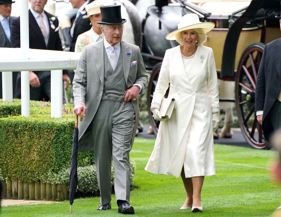 Auch König Charles und Königin Camilla lassen sich das Pferderennen nicht entgehen. Kommt euch Camillas Accessoire auch so bekannt vor? Die setzte im letzten Jahr nämlich den gleichen Hut. In diesem Jahr kombiniert sie ihn zu einem Kleid und einem Mantel von Dior.