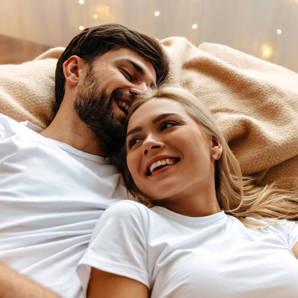 Analsex: Frau und Mann liegen sich in den Armen im Bett