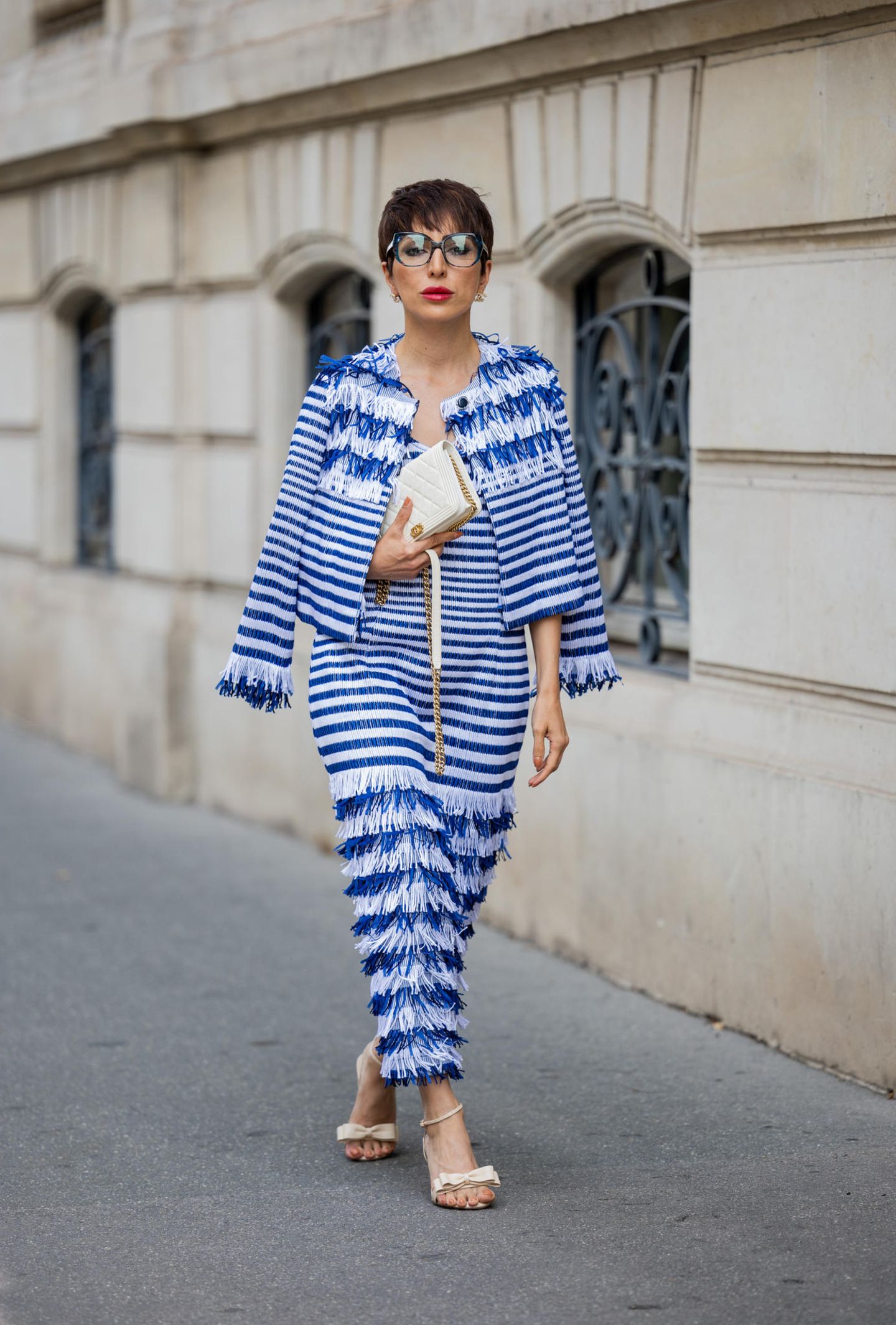 Bloggerin Salome Chaboki interpretiert bei der Haute Couture Week in Paris den Marine-Look neu. Kein Strick- oder Breton-Pullover, dafür Fransen und eine kleine Chanel-Bag. Süßes Detail: die Heels mit Schleife. 