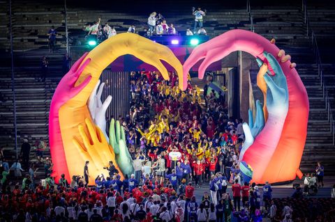 Special Olympics: Das deutsche Team betritt durch einen Herzbogen aus riesigen Armen das Olympiastation