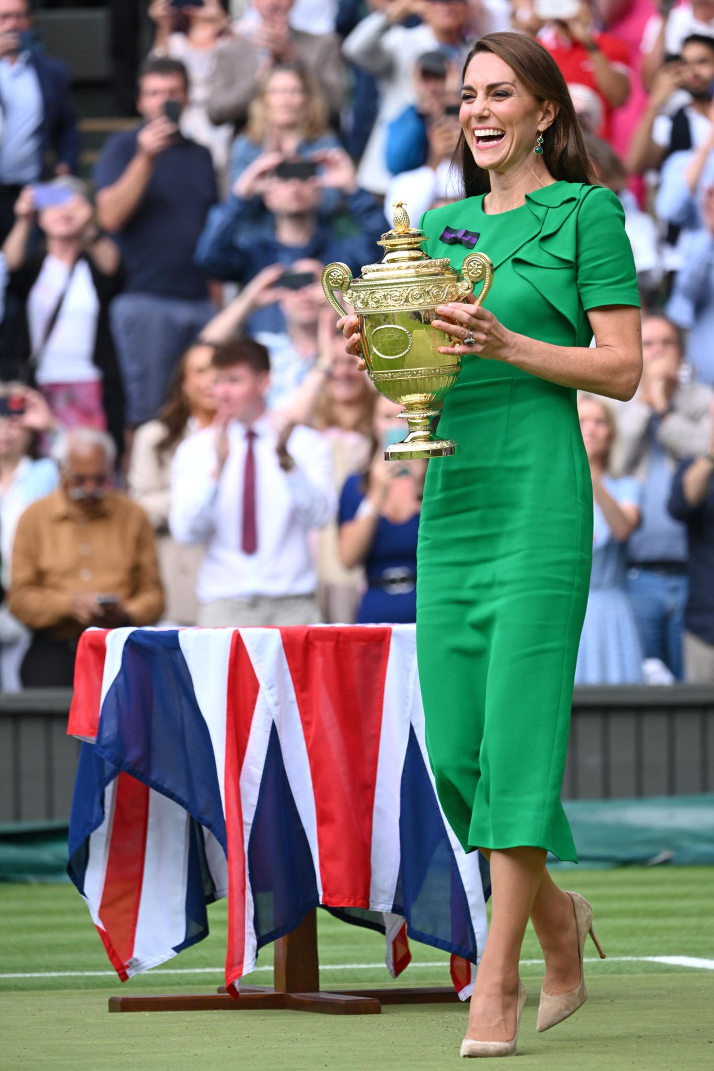 Fröhlich strahlend überreicht Catherine den Siegerpokal an den Gewinner des diesjährigen Men's Final in Wimbledon, Carlos Alcaraz. Neben dem ansteckenden Lächeln der Princess of Wales und dem großen goldenen Pokal in ihren Händen, fällt Fans jedoch vor allem eines ins Auge: die großen Falten auf ihrem grünen Roland-Mouret-Kleid. Auch wenn die Farbe und der Etui-Schnitt mit kleinen Rüschen überzeugen, die Tücken des hohen Viskose-Anteils ihres neuen Kleides können sie nicht ganz wett machen. 