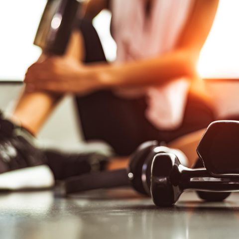 TeamTalk: Unscharfes Foto einer Frau, die im Fitnessstudio auf dem Boden sitzt