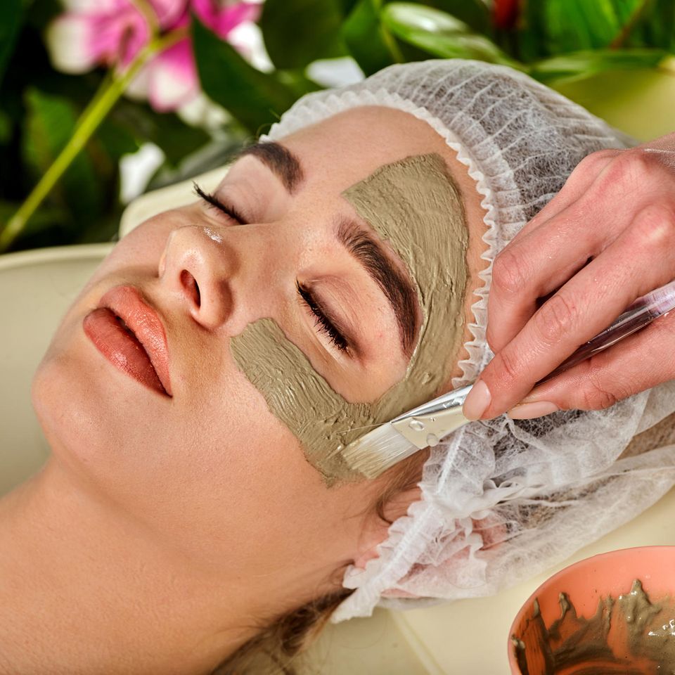 Heilerde Maske: Eine Frau bekommt eine Maske auf ihr Gesicht aufgetragen
