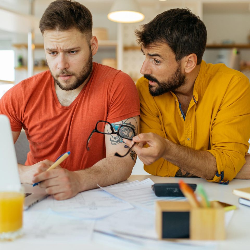 Diversität bei Finanzen: Ein homosexuelles Paar schaut kritisch auf einen Laptop