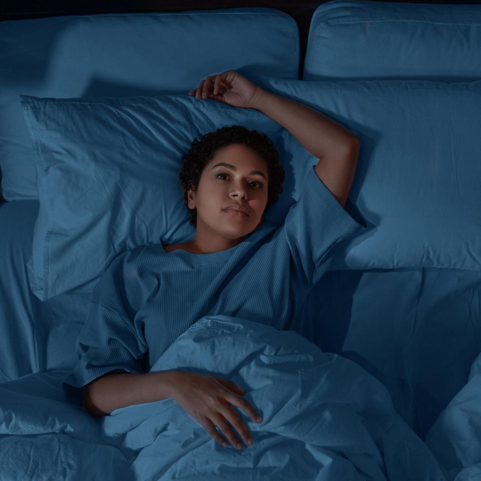 Frau liegt wach im Bett