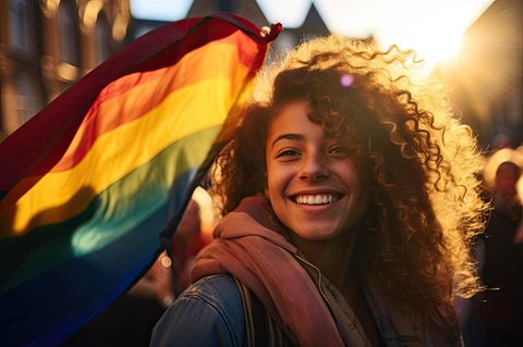 Asexualität: junge Frau mit einer Regenbogen-Flagge