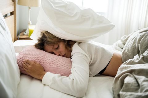 Müde Frau im Bett: 5 Anzeichen, dass du klarere Grenzen setzen solltest