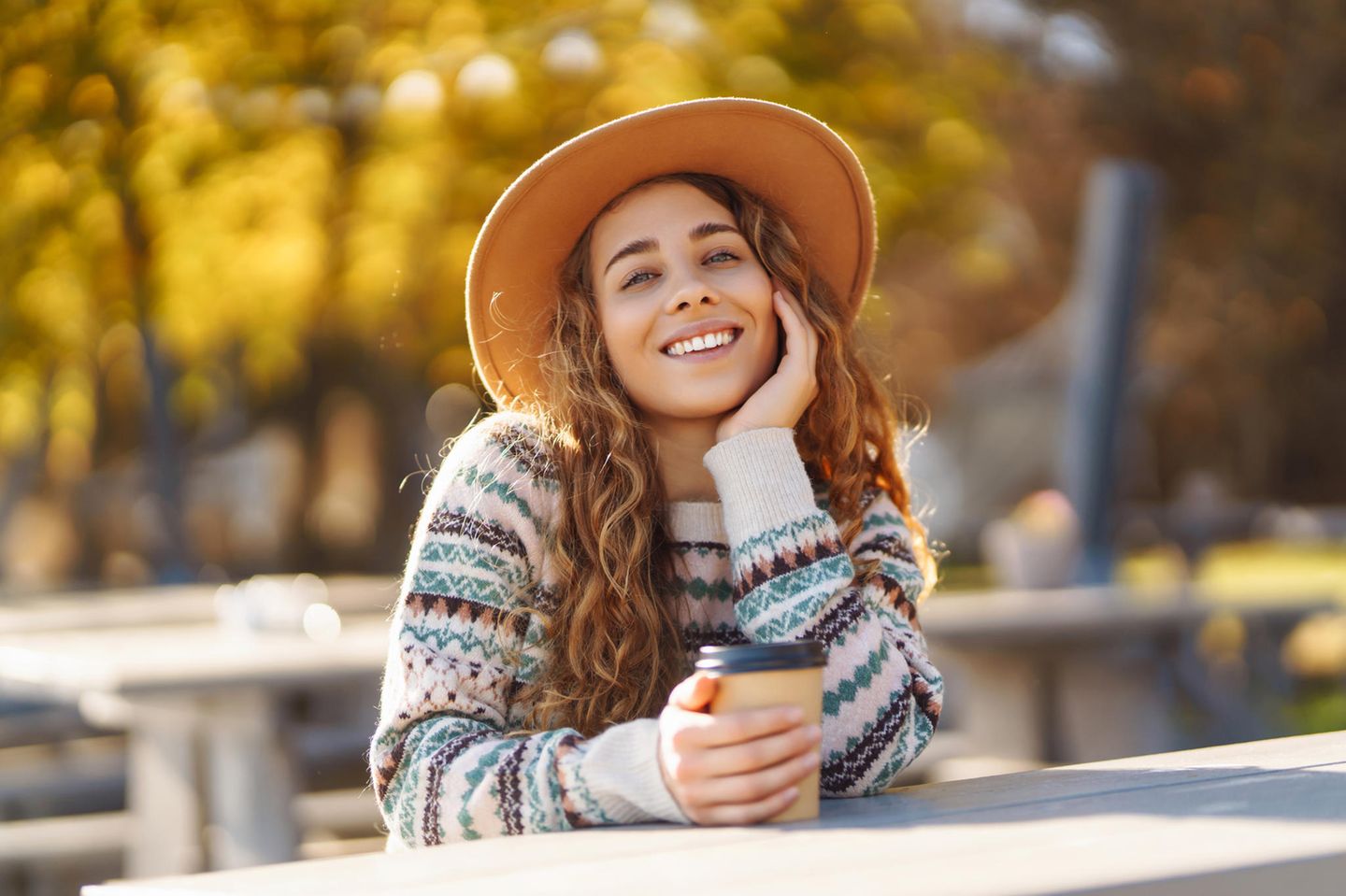 Monatshoroskop September: Frau mit Kaffee und Hut
