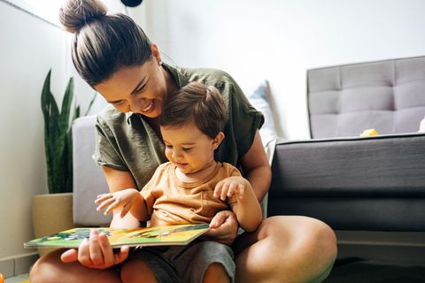 Frau liest kleinem Kind vor: Was dein Kinderwunsch über deine Persönlichkeit aussagen kann