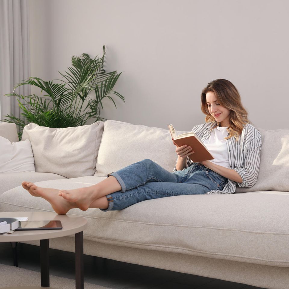 Bücher Herbst 2023: Frau liest ein Buch auf dem Sofa