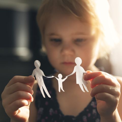 Väterrechtsbewegung: Kleines Mädchen hält ausgeschnittene Papierfiguren in der Hand