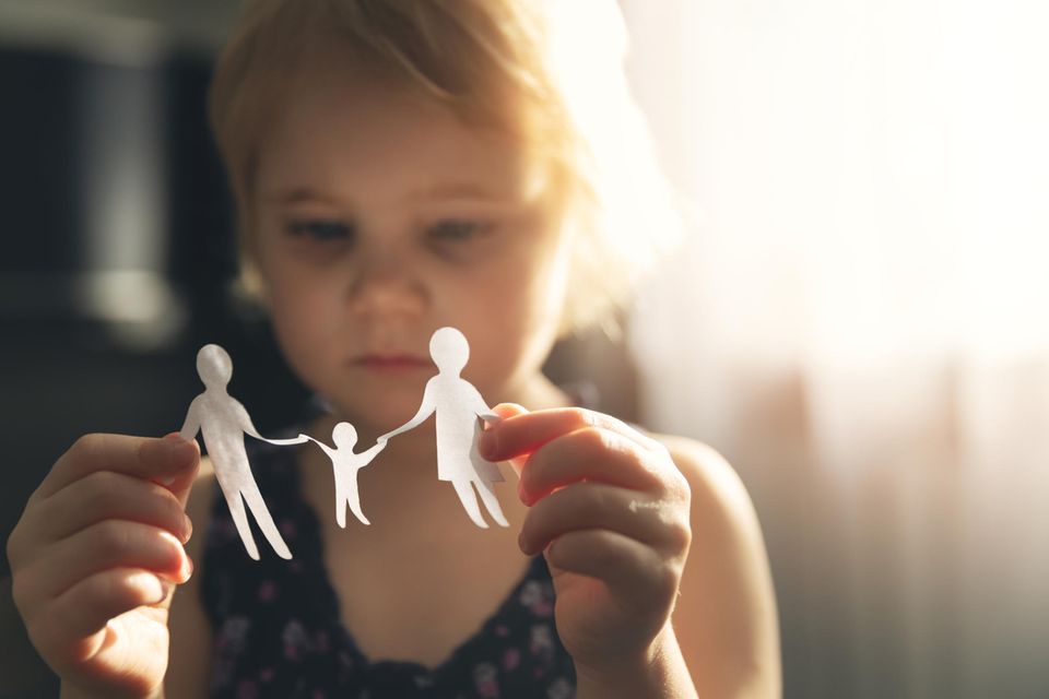 Väterrechtsbewegung: Kleines Mädchen hält ausgeschnittene Papierfiguren in der Hand