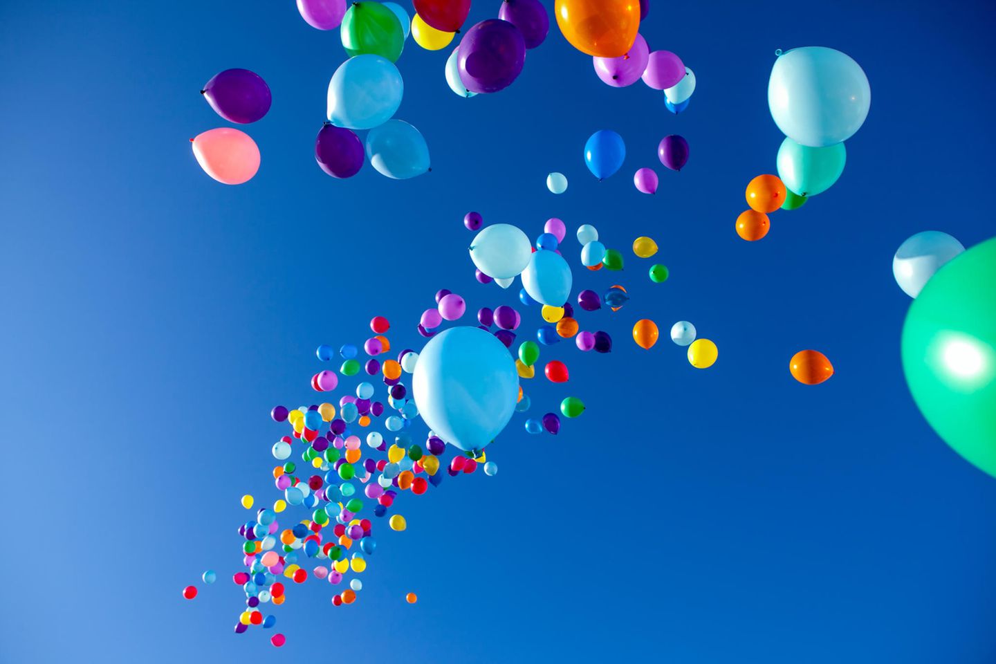 Bunte Luftballons fliegen am Himmel als Zeichen für moderne Familienpolitik