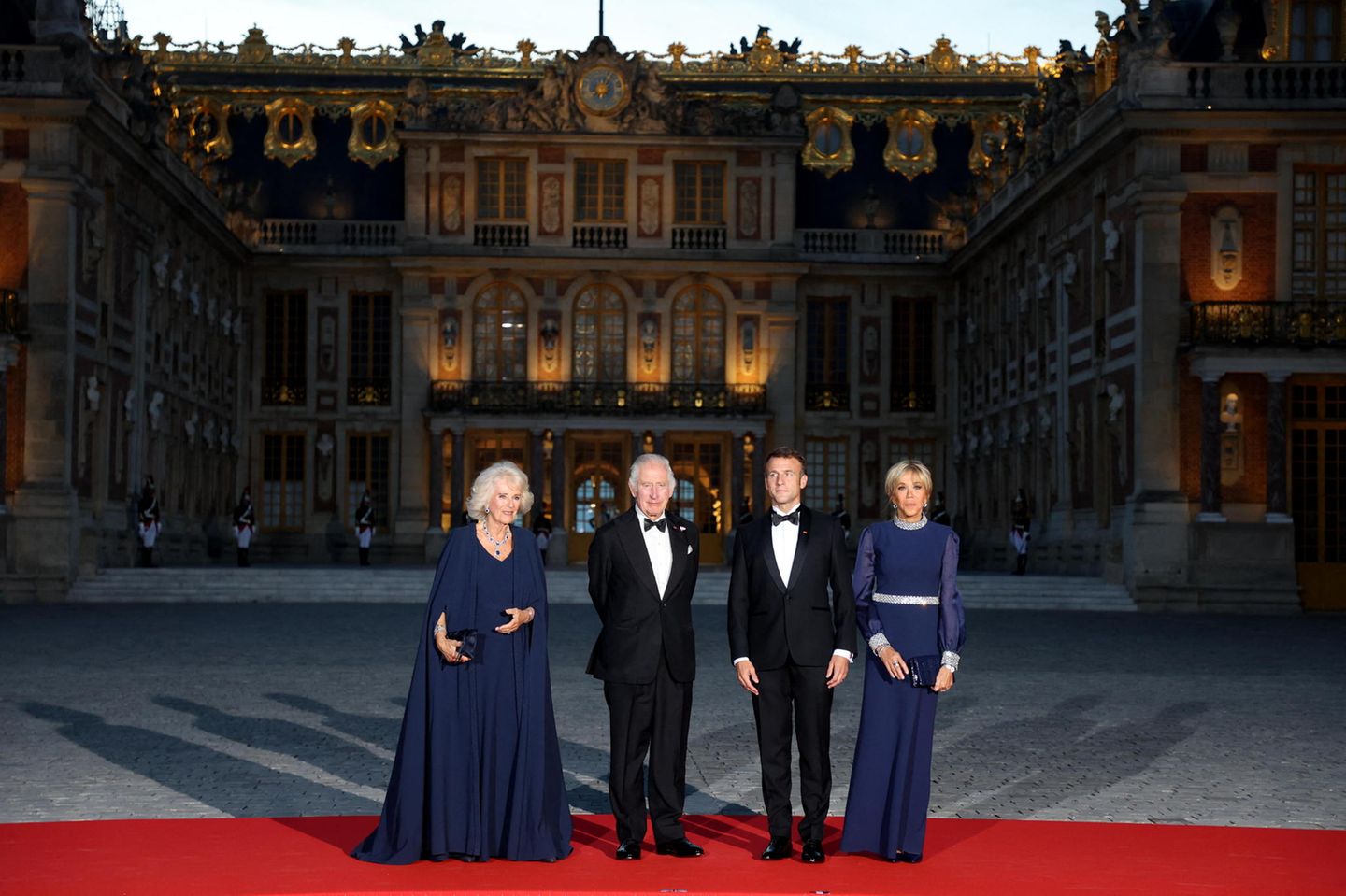 Prunkvolles Aufeinandertreffen im Schloss Versailles! Im Rahmen des Staatsbesuchs des britischen Königspaares in Frankreich zeigen sich Königin Camilla und König Charles gemeinsam mit Emmanuel und Brigitte Macron in glanzvoller Einheit. Während die Männer in klassischen Anzügen kein Risiko eingehen, scheinen sich ihre Frauen miteinander abgesprochen zu haben. In blauen Roben vollenden sie das anmutige Bild und symbolisieren damit auch modisch ihre Zugewandtheit. Clever! So stehlen sie sich gegenseitig nicht die Show. 