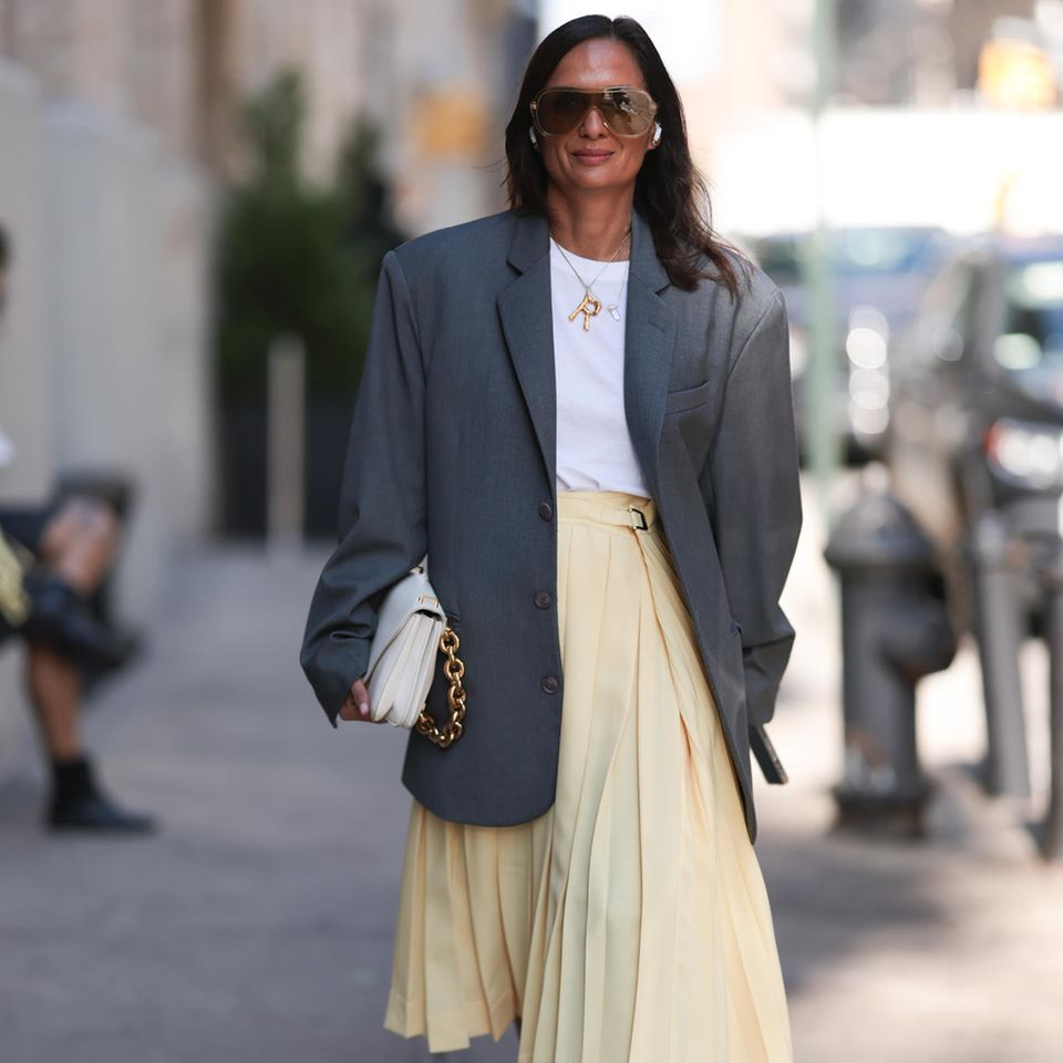 Es ist wieder Zeit für die großen Modewochen. Bei dem Auftakt in New York haben die Gäste sich selbst übertroffen. Außerhalb der Brandon Maxwell Show trägt eine Gästin einen grauen overzised Blazer, ein schlichtes weißes T-shirt und einen pastell-gelben asymmetrischen Faltenrock. Gepaart mit einer weißen Tasche von Bottega Veneta und einer vintage Kette von Céline, strahlt sie den perfekten Mix zwischen Chic und Lässigkeit aus.