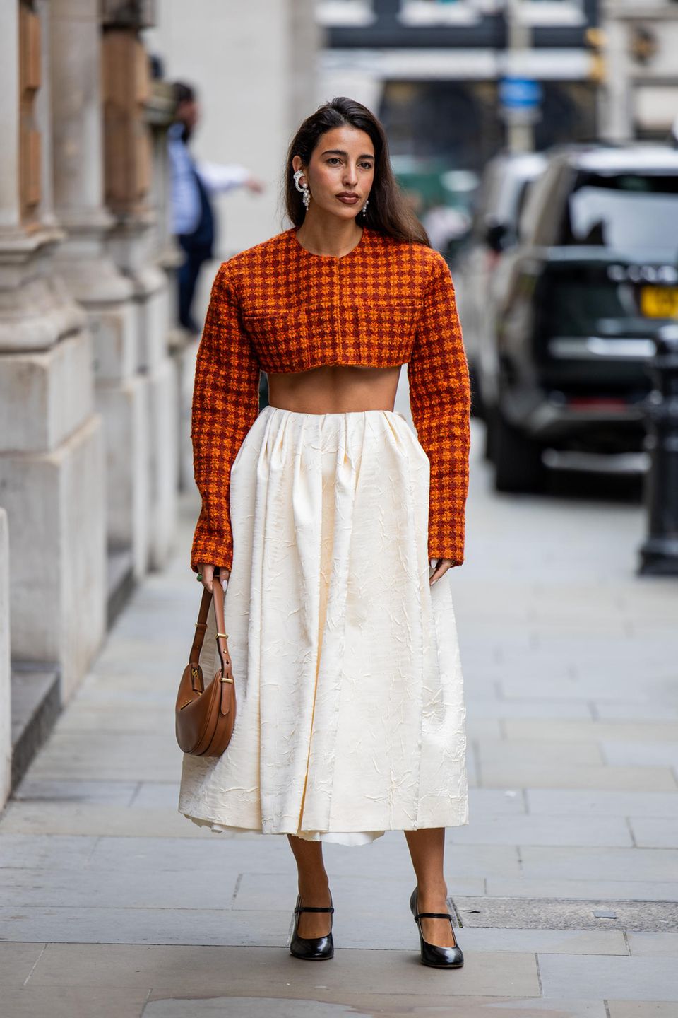 Auch auf den Straßen von London lassen die Styles nicht zu wünschen übrig. Besonders passend für den Herbst, spielt kräftiges Orange eine große Rolle. Bettina Looney zeigt sich vor der Show von Emilia Wickstead in einem orangefarbenen Crop-Hemd und einem langen cremefarbenen Rock.