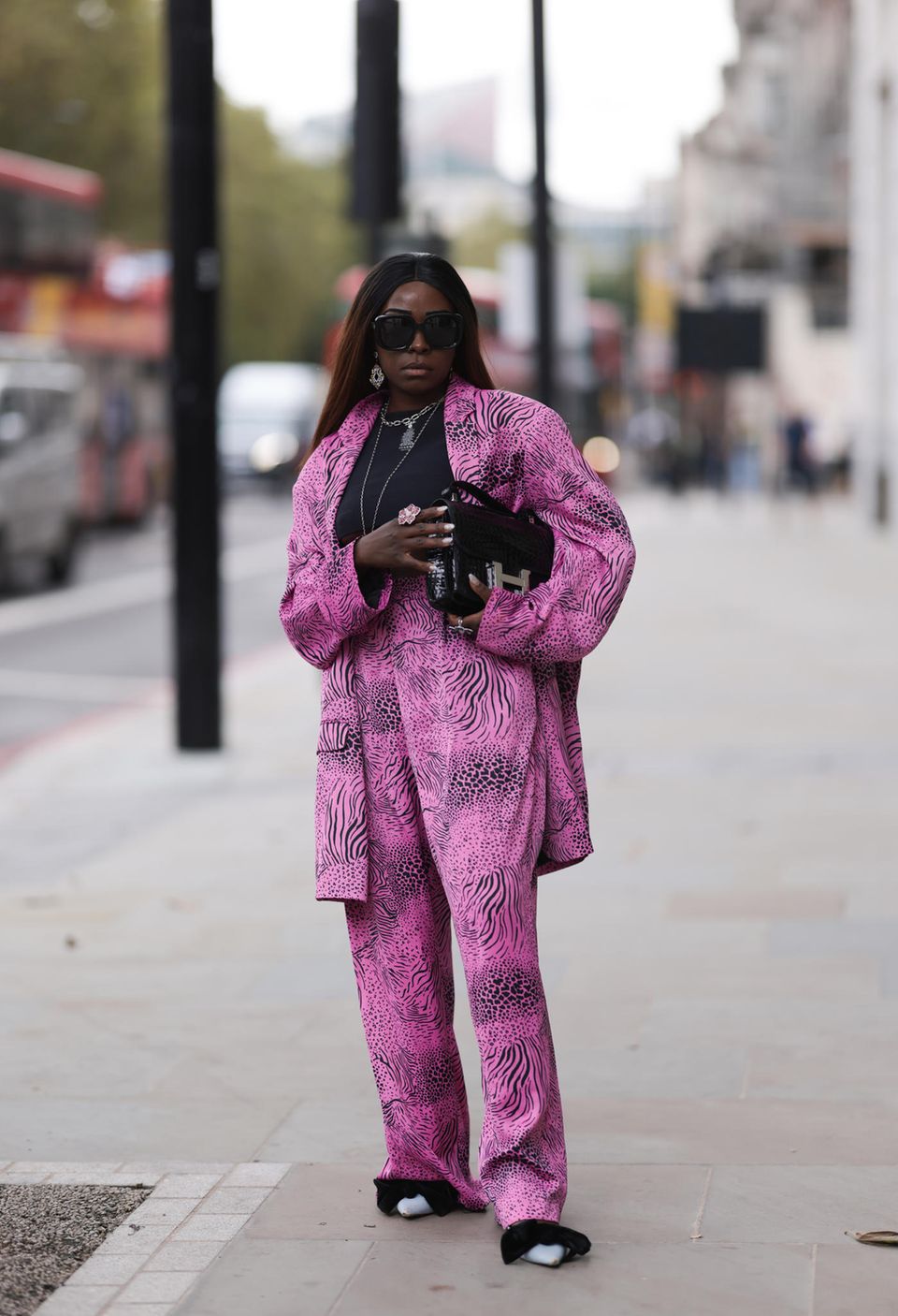 Susan Mutesi trägt einen Pyjama ähnlichen Look mit Animalprint. Die farbenfrohe Kombi ist von Asos und die Schuhe von Zara. Mit ihrer Constance Hèrmes-Tasche zeigt sie uns, dass man Luxus auch sehr gut mit Stangenware kombinieren kann.