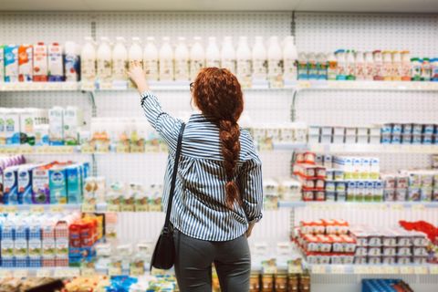 Frau vor dem Milchregel im Supermarkt